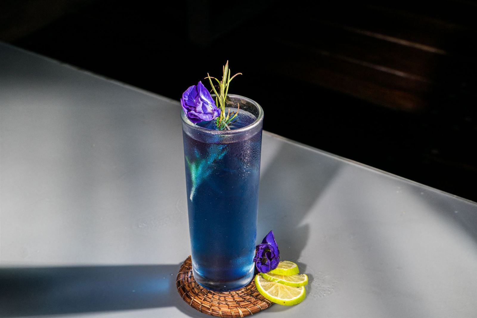 Coctel azul con flor de mariposa y limón
