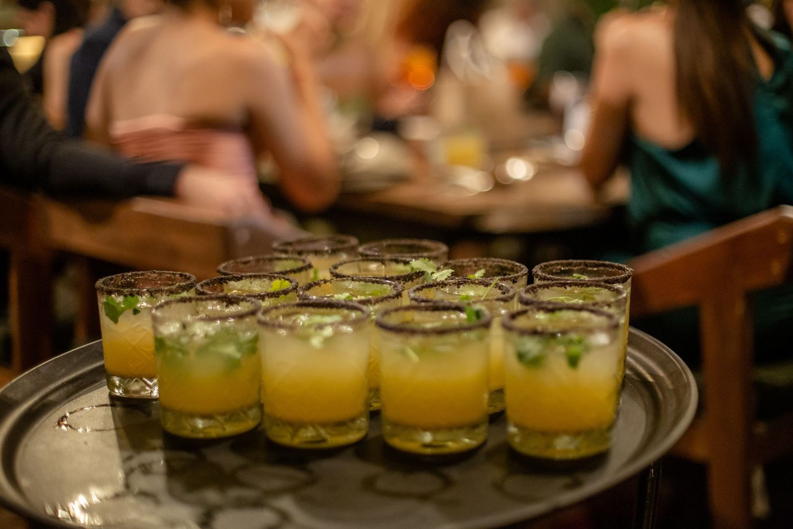 Charola llena de mezcalitas en una noche concurrida