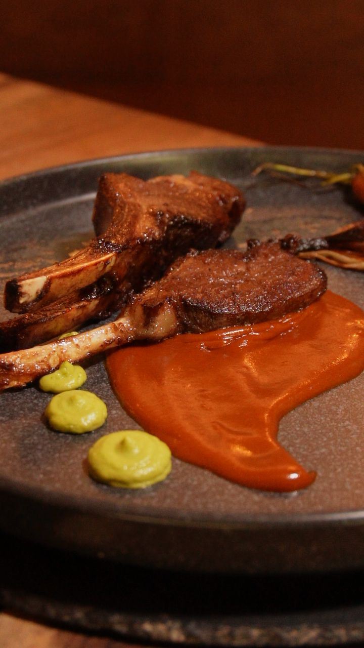 Carne al carbón con salsa naranja en plato oscuro
