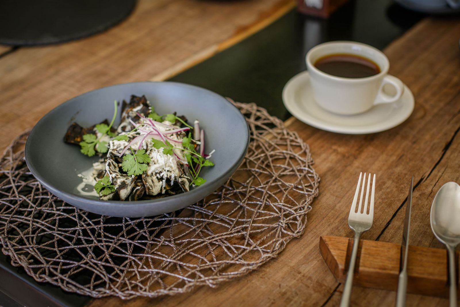 Ensalada verde en plato gris sobre mesa de madera