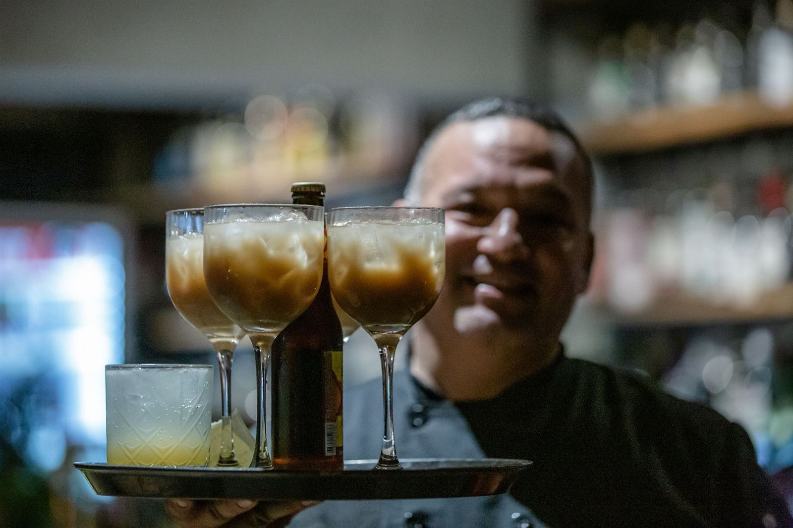 Integrante del equipo de Waah sonriendo con una charola de bebidas